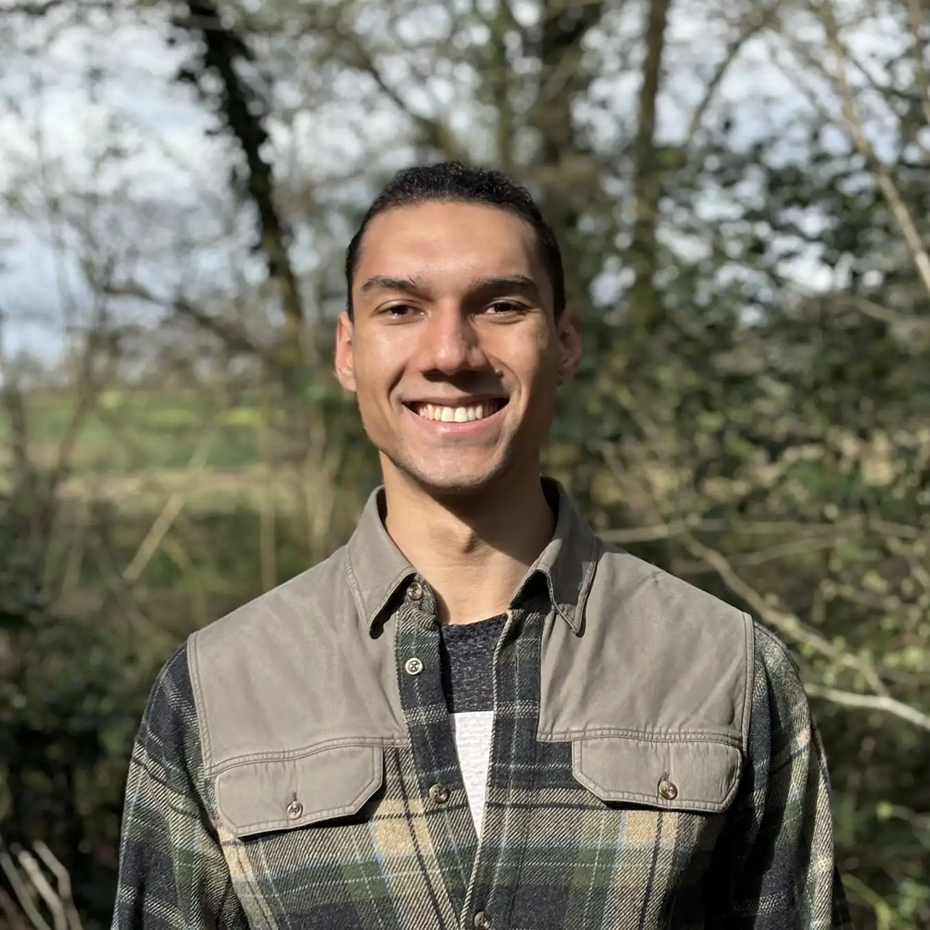 Shane, Rootd team member, standing outside with trees in the background